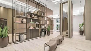 Un intérieur moderne avec un présentoir en verre, un coin salon et des plantes en pot.