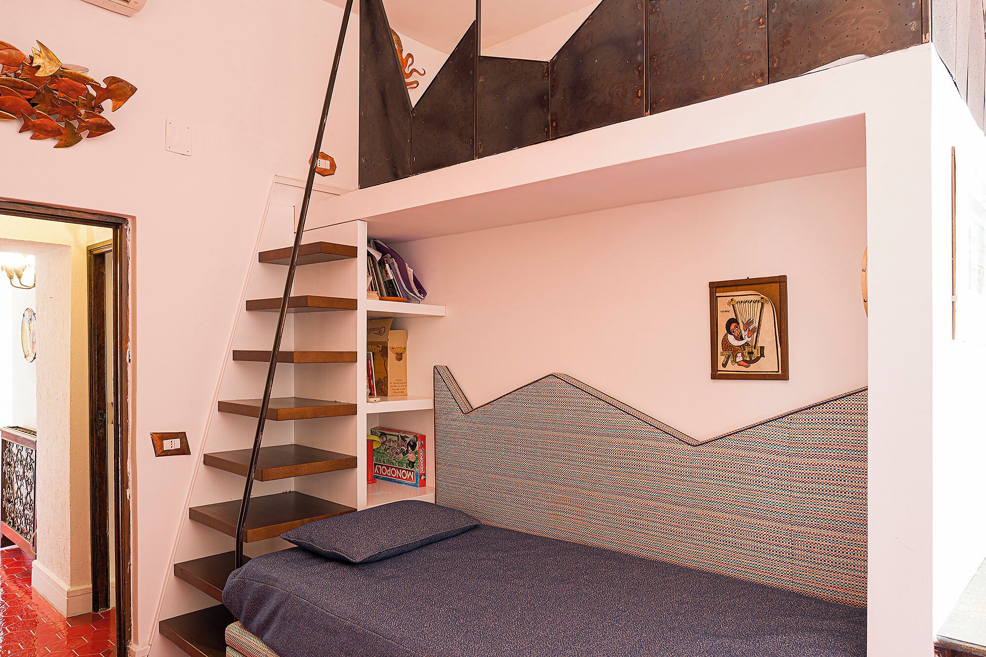 A bedroom with a bed, a bookshelf, a ladder, and a wall-mounted shelf.