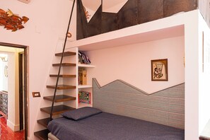 A bedroom with a bed, a bookshelf, a ladder, and a wall-mounted shelf. - Luna Rossa, Capri (Capri)