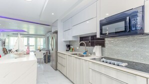 A modern kitchen with a built-in microwave, stainless steel appliances, and a marble countertop. - Palomino & Icacos Trips / Near El Yunque & Bio Bay (Fajardo)