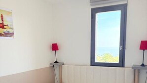 Un dormitorio con cama, ventana con vistas y dos lámparas de noche.