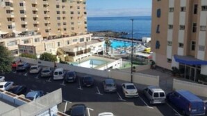 Un hotel con piscina, parcheggio e vista sull'oceano.