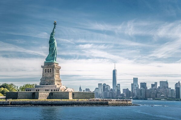 La statue de la Liberté à New York, avec la silhouette de la ville en arrière-plan.