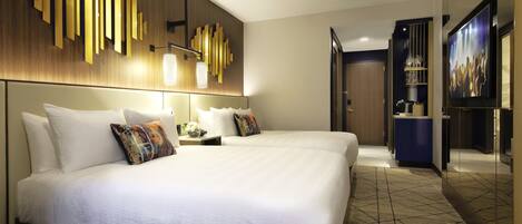 Una habitación de hotel con una cama grande, un revestimiento de pared de madera, un televisor y un minibar.