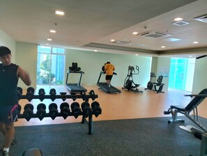 A gym with treadmills, an elliptical, and a dumbbell rack. - Chic Cebu Staycation - Condo Studio Balcony Mivela Garden, Free WIFI and Neflix (Cebu City)