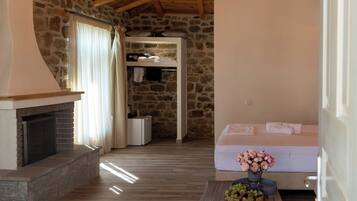 Un interior rústico con pared de piedra, techo de madera y chimenea.