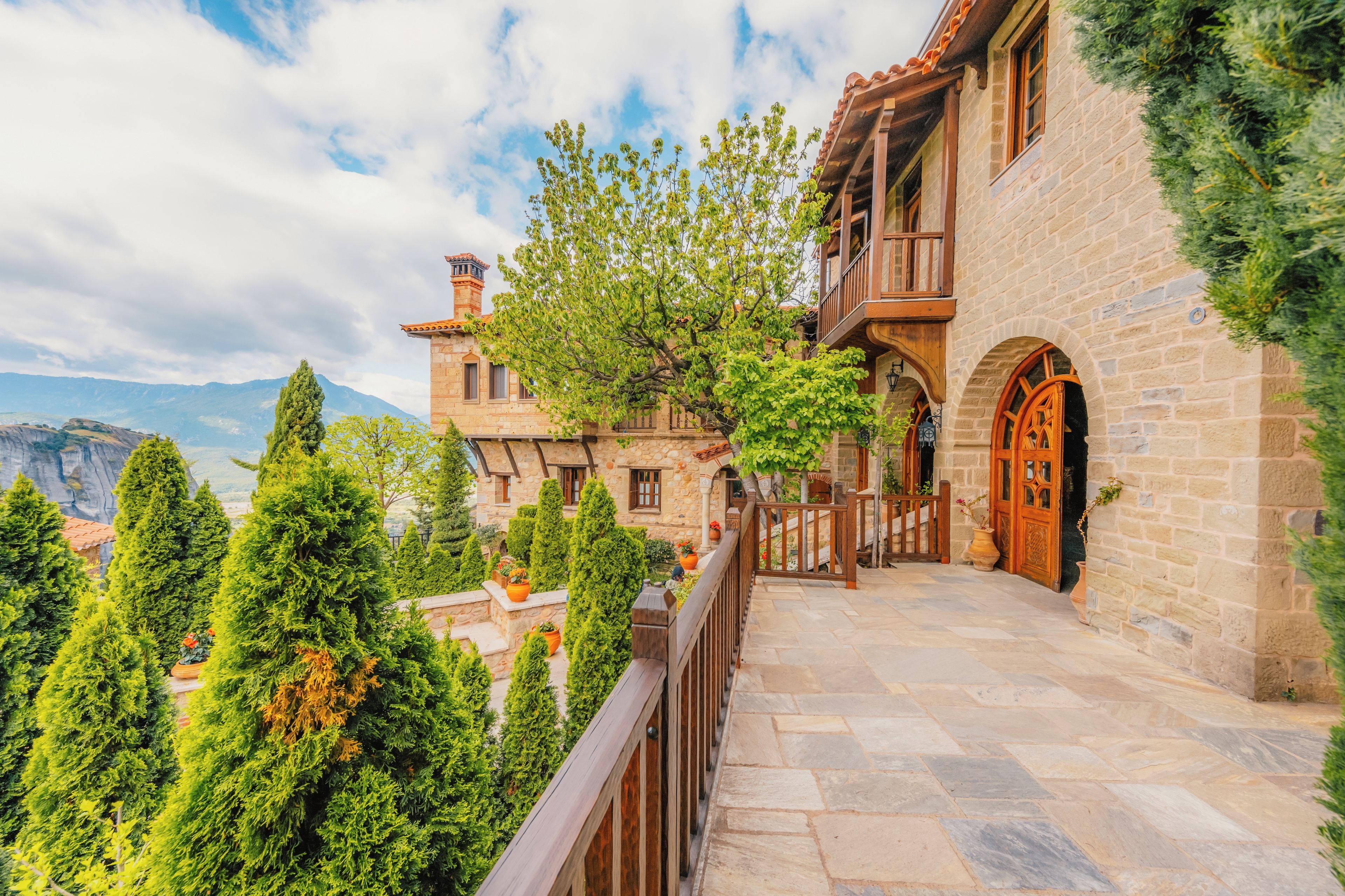 A stone building with a balcony overlooking a mountainous landscape.