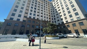 A high-rise building with multiple floors, a central courtyard, and a parking area with cars. - 1991 Home Sapa | Fully Equipped Apartment | 5 min to Sapa Center (Sa Pa)