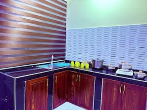 A modern kitchen with a built-in sink, wooden cabinets, and a backsplash with a striped pattern.