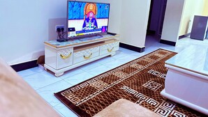 A television on a white cabinet with a patterned rug on the floor.