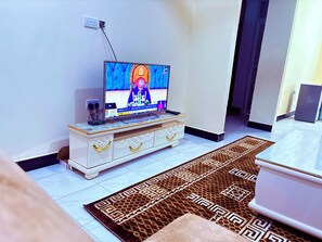 A television on a white cabinet with a patterned rug on the floor.
