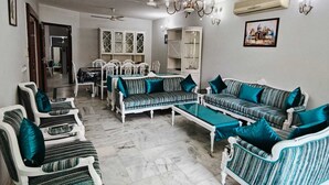 Ein Wohnzimmer mit Essbereich, weißen Möbeln und einer Chandelüster.