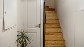 A staircase with wooden steps and a white door at the top. - Downtown Modern Apartments I by Homing (Lisbon)