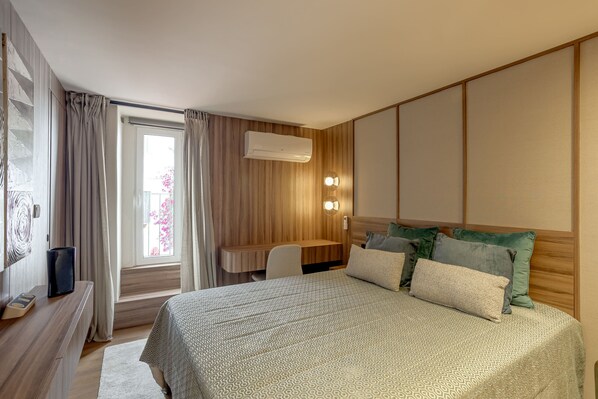 A modern bedroom with a large bed, a desk, and a window with curtains. - Principe Real Prime by Homing (Lisbon)