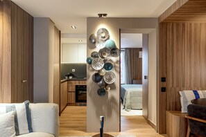 A modern interior with a central decorative wall, wooden paneling, and a kitchen area in the background. - Principe Real Prime by Homing (Lisbon)