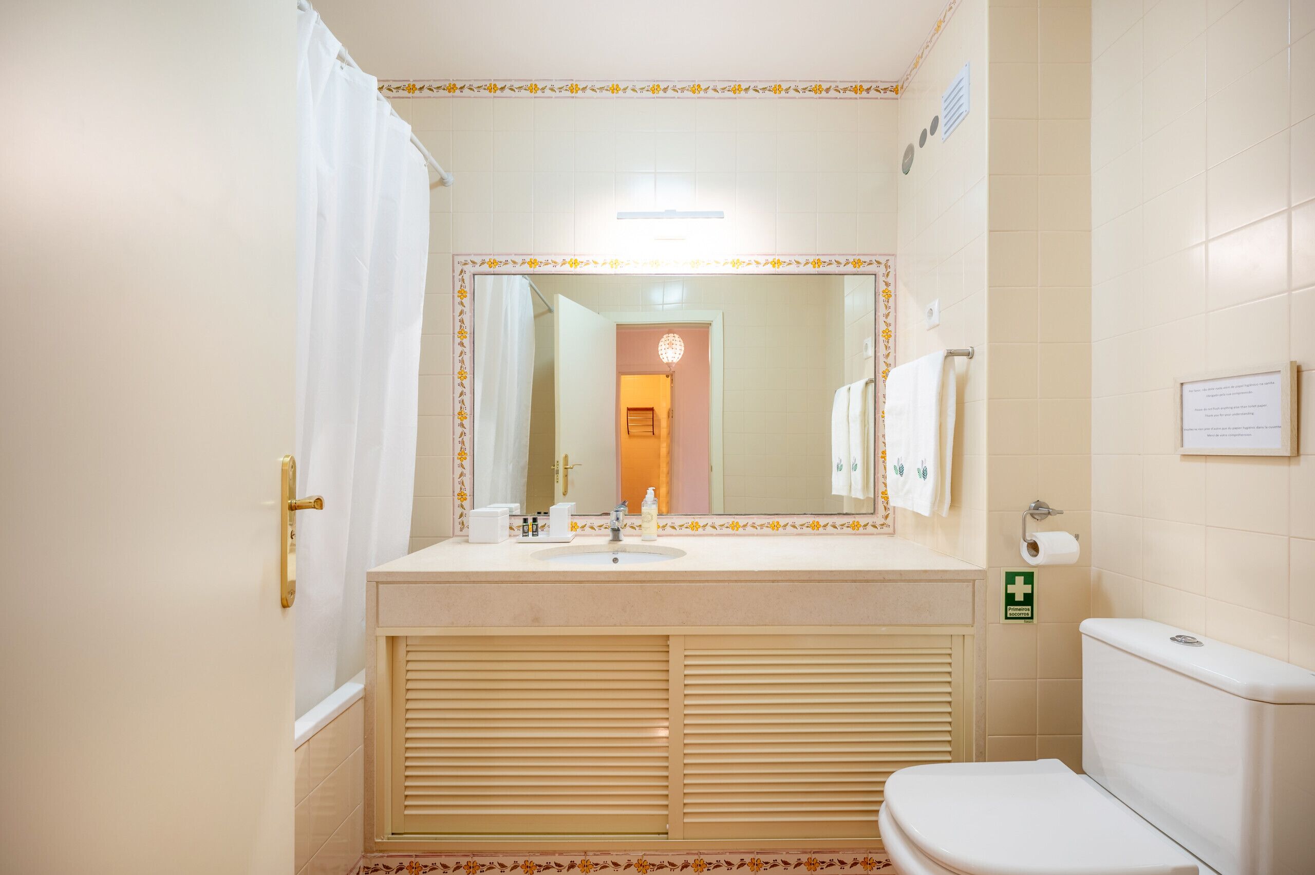 A bathroom with a sink, toilet, and mirror.