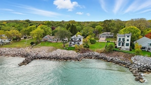 Un quartier résidentiel avec des maisons, une côte rocheuse et une vue dégagée sur l’eau.