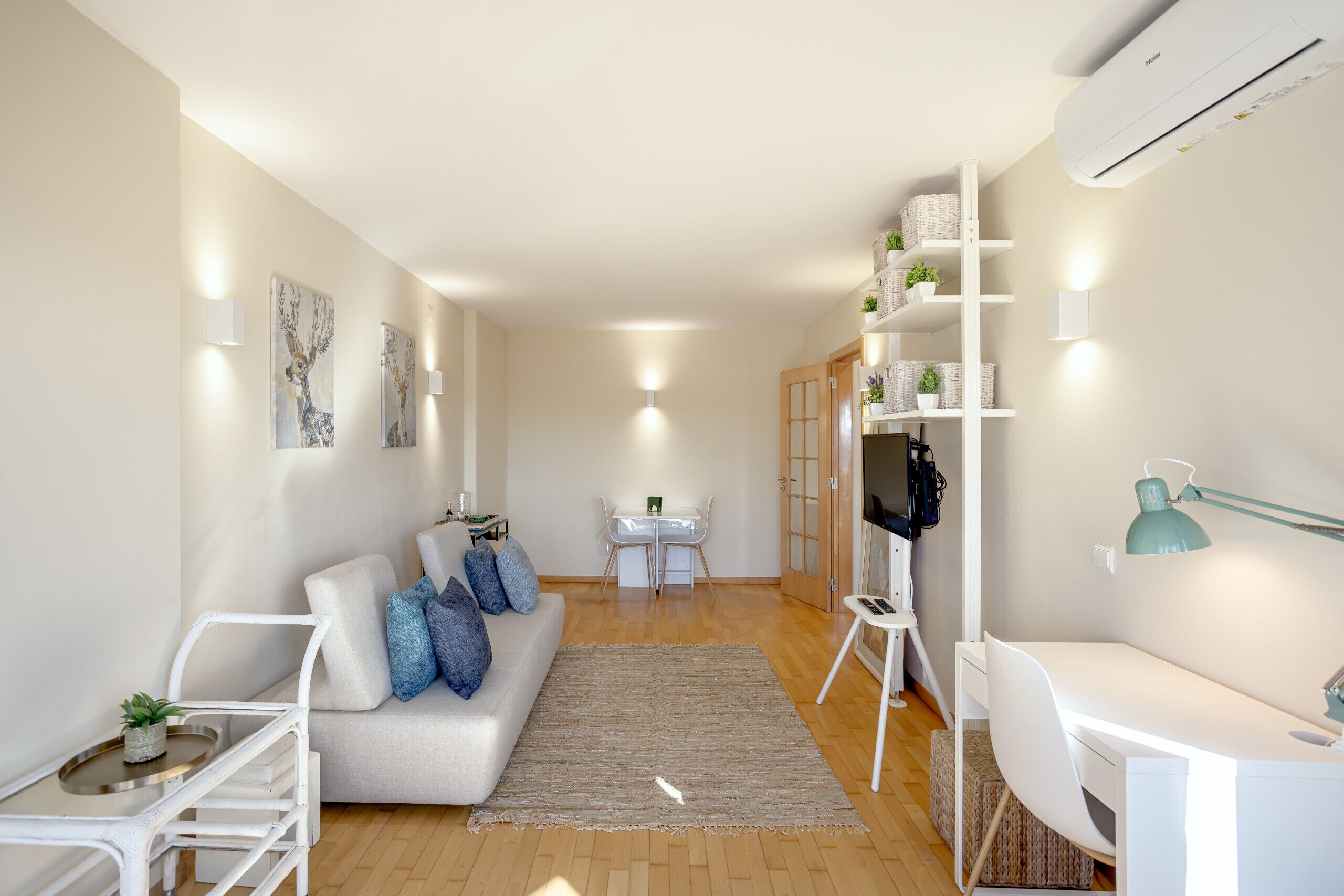 Una sala moderna con un sofá, una mesa de comedor y un espacio de trabajo con una silla.