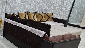 Ein modernes Schlafzimmer mit Schlafsofa, Flachbildfernseher und Wand mit Marmor-Muster.