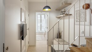 A modern interior with a staircase, a flat-screen TV, and a pendant light. - Downtown Modern Apartments by Homing (Lisbon)