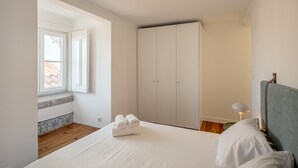 Quarto com cama, guarda-roupa, janela e abajur.