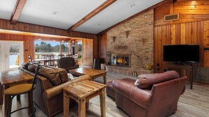 Una sala de estar acogedora con chimenea, muebles de cuero y televisor.