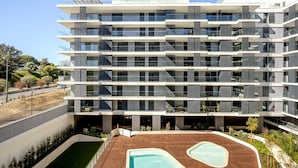 A multi-story building with balconies, a rooftop pool area, and a landscaped garden. - Modern Lisbon W/ Balcony Pool II (Lisbon)