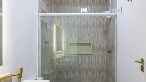 Un baño con ducha, inodoro y lavabo.