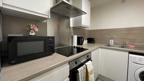 A compact kitchen with a microwave, toaster, kettle, sink, and dishwasher. - Downtown Sheffield Retreat (Sheffield)