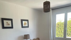 A bedroom with two beds, a bedside table, a lamp, and framed pictures on the wall. - Minorcan house (S'Algar)