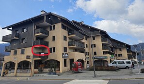 A multi-story building with balconies, a restaurant named 'Le Peille,' and a pharmacy. - Apt in St Jean de Sixt Heart with Balcony (Saint-Jean-de-Sixt)