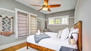 A bedroom with a bed, ceiling fan, bedside lamp, and a window with blinds. - Riverwalk Path! Heart of South Main w/ Peak Views (Buena Vista)
