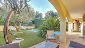 A patio area with outdoor furniture, a pool, and a view of the garden. - Villa with heated pool in Sainte-Maxime (Sainte-Maxime)