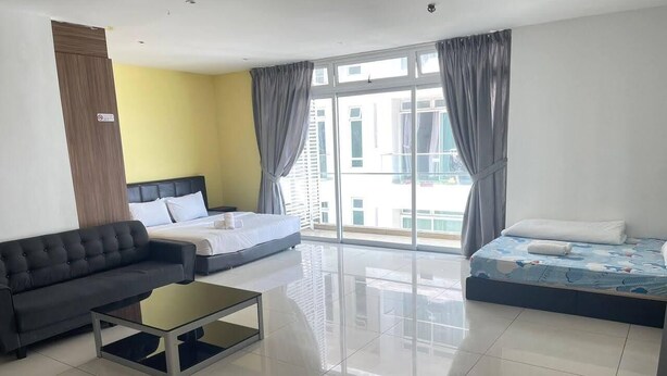 Une chambre d’hôtel moderne, dotée d’un canapé, d’un lit, d’une petite table et de grandes fenêtres avec des rideaux.