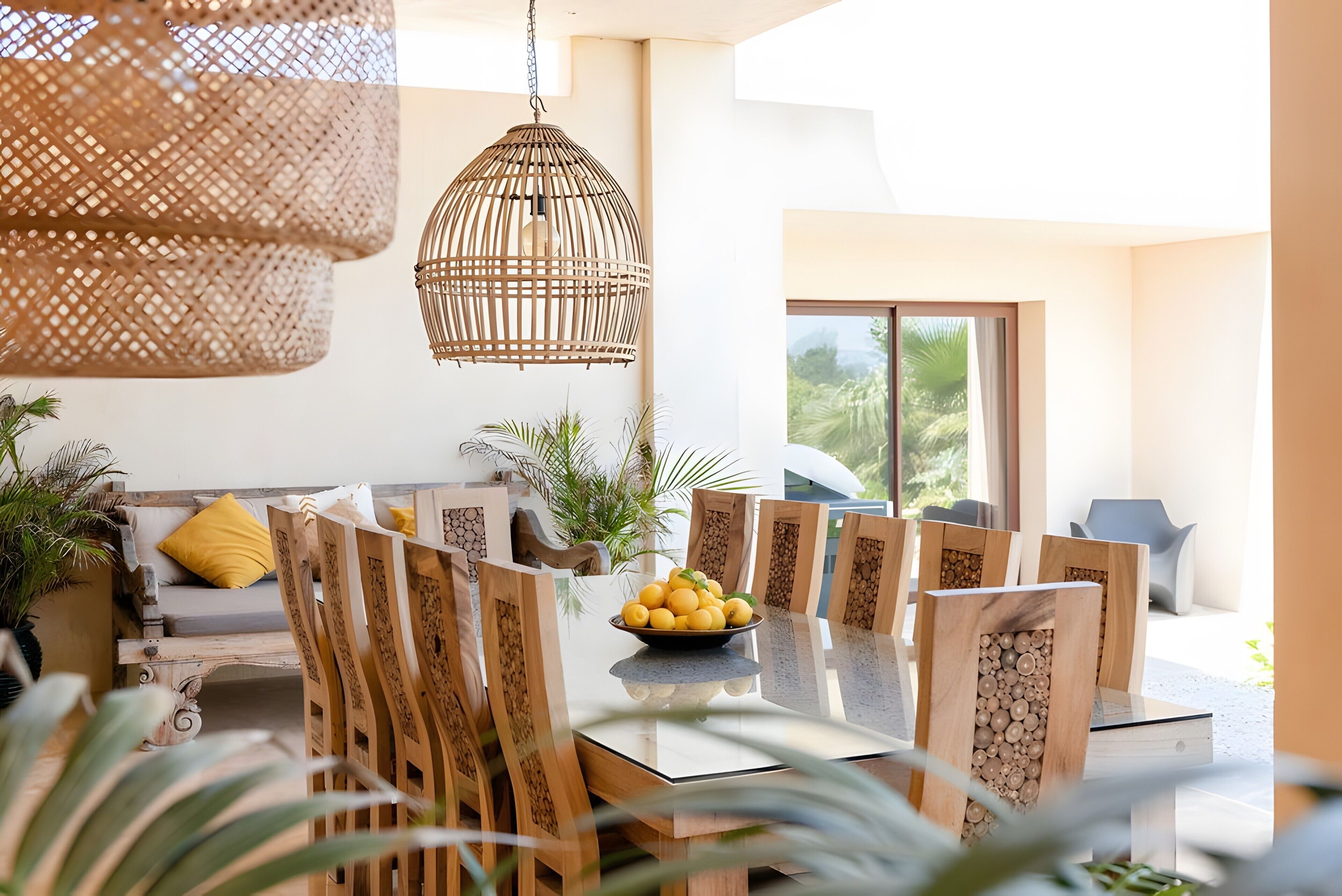 Un comedor con una mesa de madera, sillas y un cuenco de fruta.