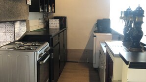 A kitchen with a stove, oven, and a coffee machine. - Gite Eltiwen esprit bar (la croix hellean)