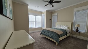 A bedroom with a bed, a desk, a ceiling fan, and a window with blinds. - Cozy 2-bedroom villa in marvelous Fort Myers with AC (Fort Myers)