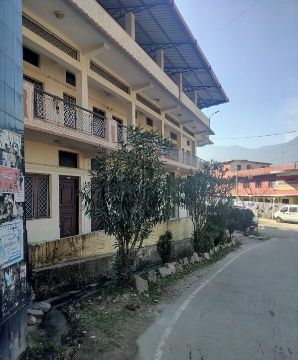 A multi-story building with balconies, a gated entrance, and a road in front. - Saalak Lite Social Palace  (Ukhimath)