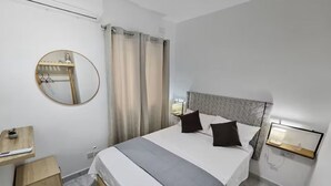 Ein Schlafzimmer mit Bett, Nachttisch, Spiegel und Beistelltisch.