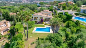 Zona residencial amb piscina, vegetació exuberant i cases d'arquitectura mediterrània.