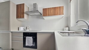 Eine moderne Küche mit eingebauten Geräten, Holzschränken und einer Edelstahlspüle.