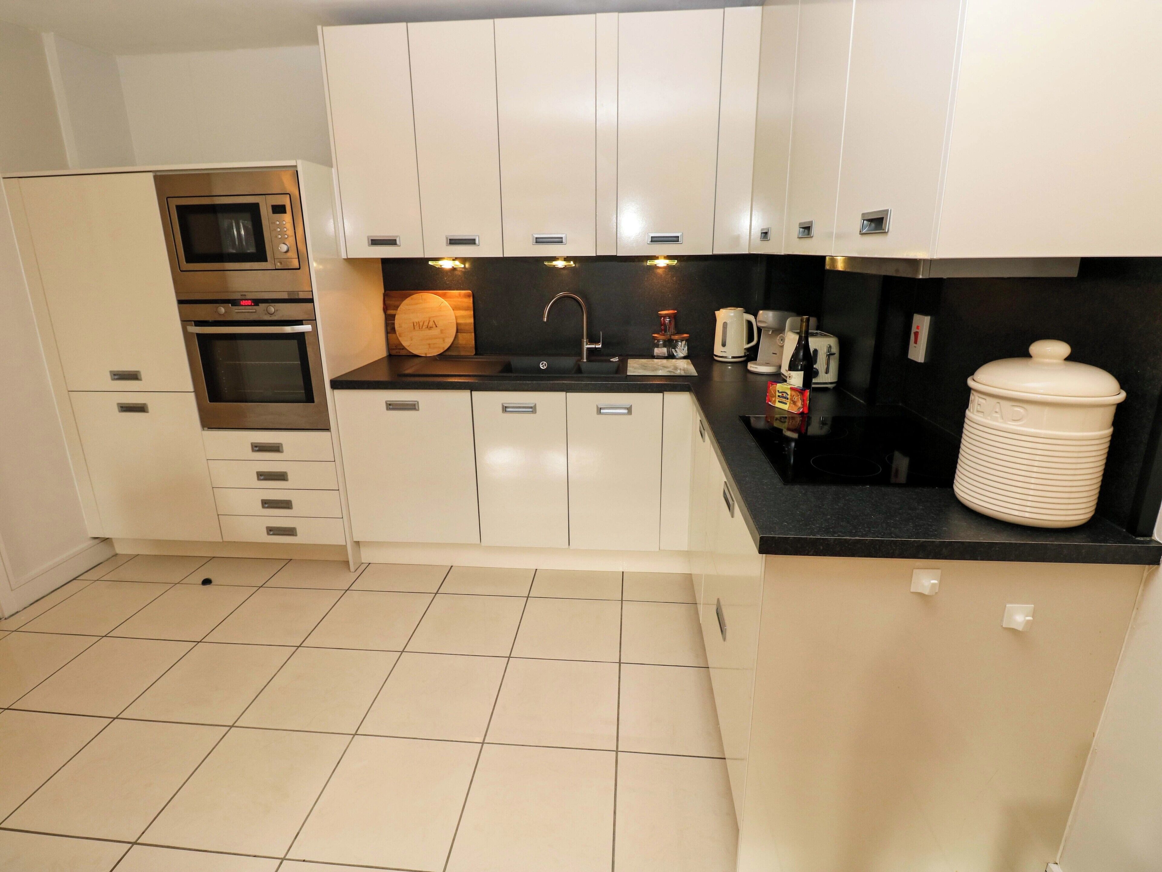 A compact kitchen with a microwave, oven, and a coffee maker.