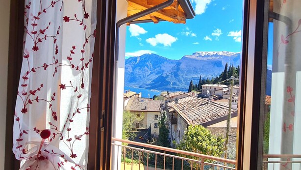 A balcony with a view of a mountainous landscape and a village below. - Villa La Pief - Gardasee Blick (Tremosine)