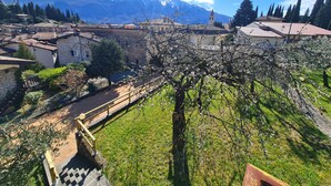 A mountainous landscape with a church spire, traditional buildings, and a clear sky. - Villa La Pief - Gardasee Blick (Tremosine)