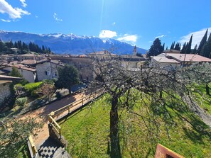A mountainous landscape with a church spire, traditional buildings, and a clear sky. - Villa La Pief - Gardasee Blick (Tremosine)