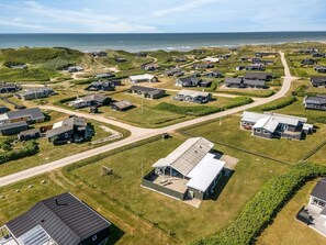 An aerial view of a coastal residential area with houses, roads, and a beach in the background. - 4 Star Holiday Home in Lokken (Lokken)