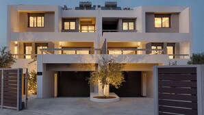 Un bâtiment moderne à deux étages, doté d’un toit plat, de grandes fenêtres et d’une cour intérieure avec un arbre.