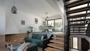 Un salon moderne avec un canapé, une table basse et un escalier.