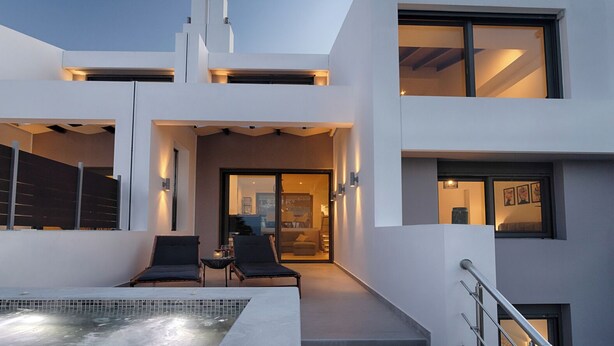 Un bâtiment moderne à deux étages doté d’une piscine, d’un espace extérieur aménagé et d’un patio couvert.