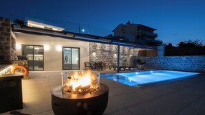 A modern house with a swimming pool, outdoor seating, and a fire pit. - Ozen Suite, Ozen Suite & Villa Crete (Agios Nikolaos Crete)